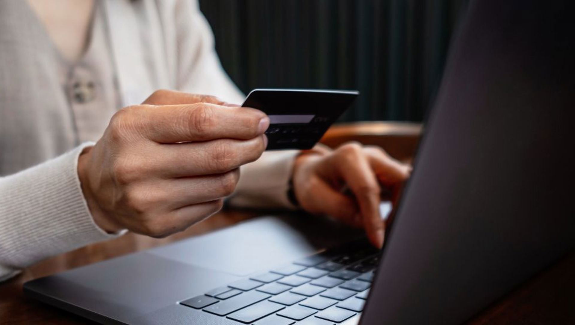 Woman holding card and laptop (1336 × 560px)