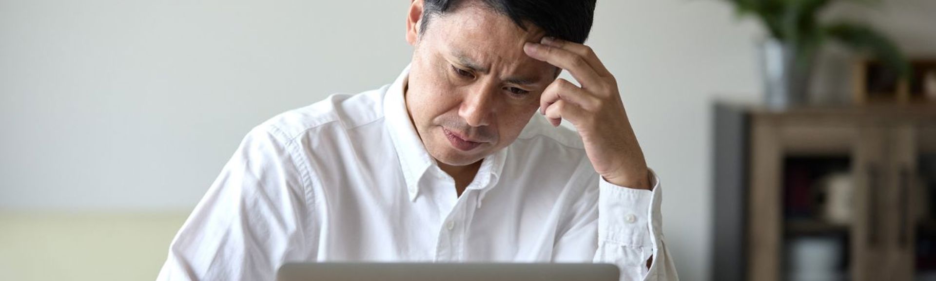 Man concerned at laptop HERO (1336 × 560px) (2)