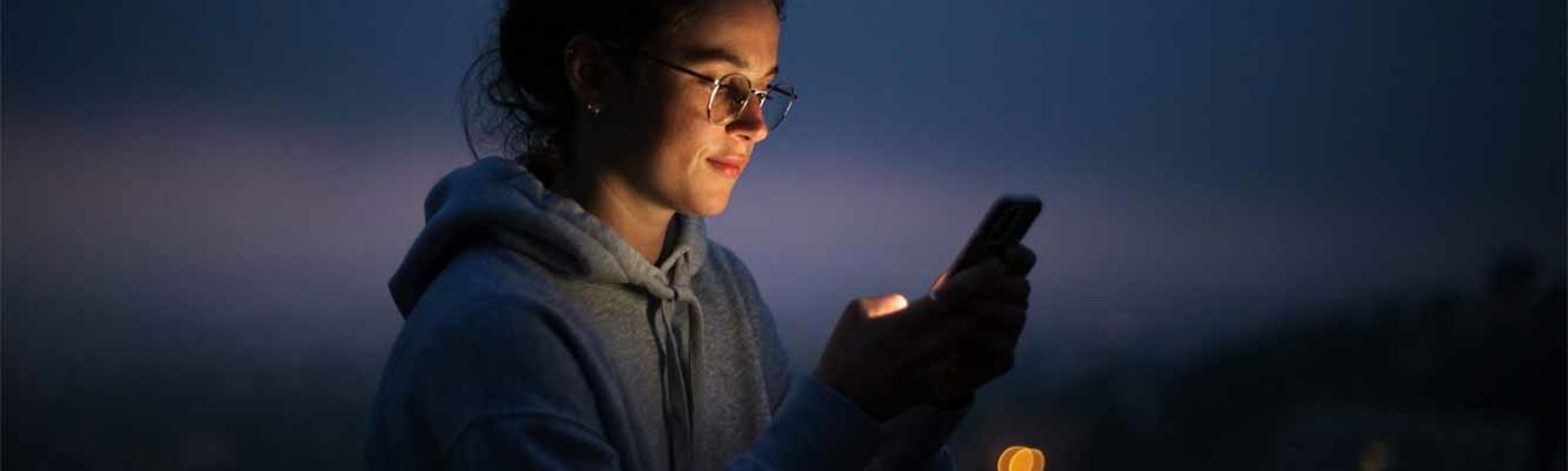 A woman using a mobile phone at night