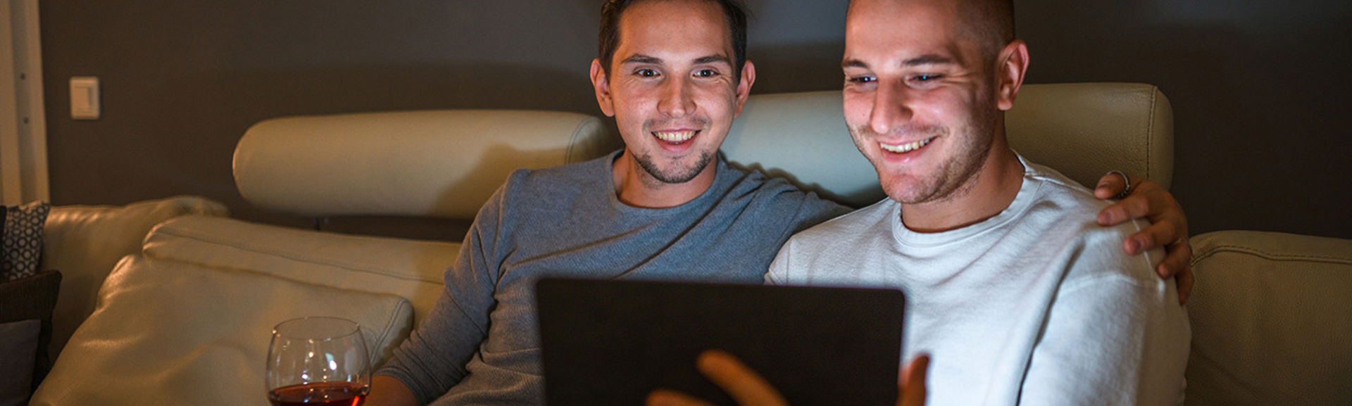 Two men on a sofa looking at a tablet