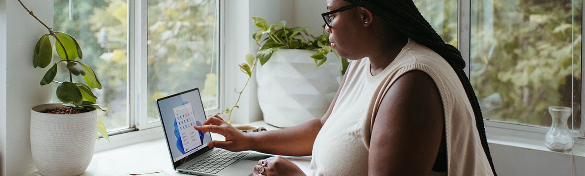 A woman at desk using a laptop and calculator