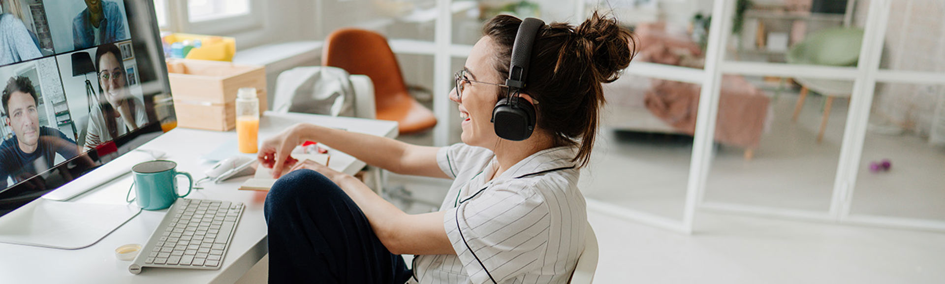 A woman smiling at her computer screen as she talks to people on a video call