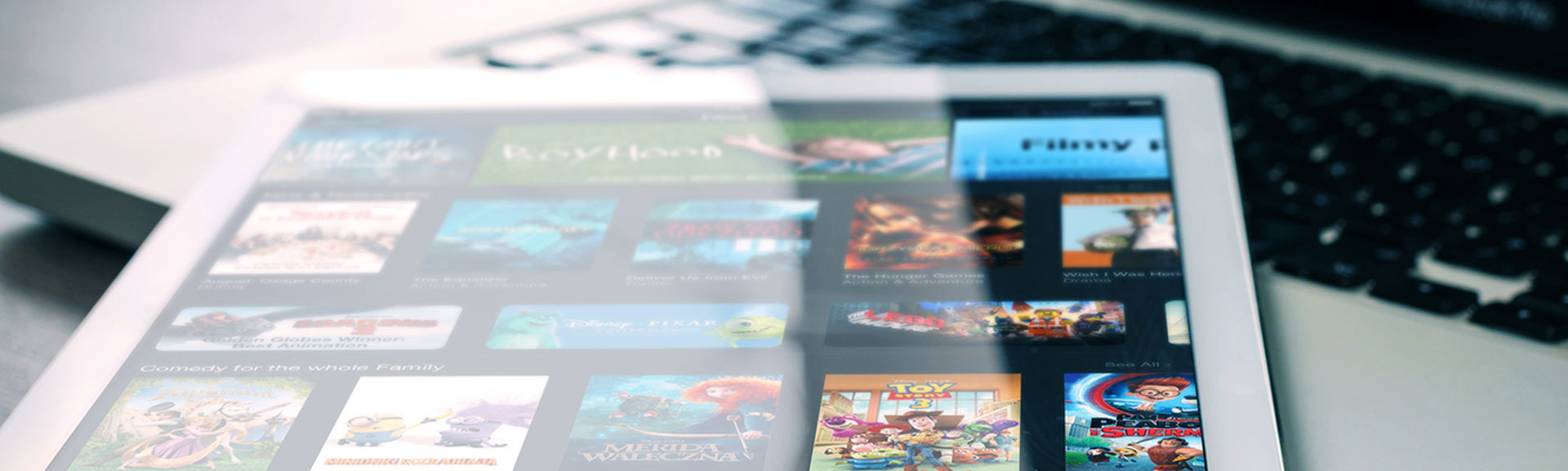 A tablet device with a streaming app open and a number of film titles on screen