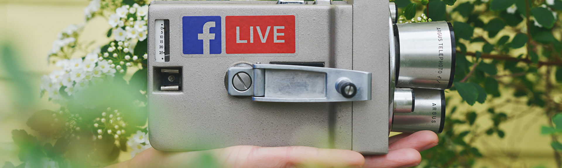 An old-style video camera with the Facebook logo and a 'live' sticker on it
