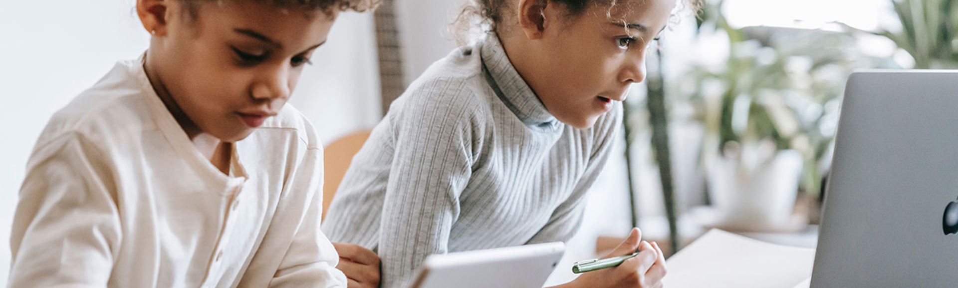 Two young children using tablet devices