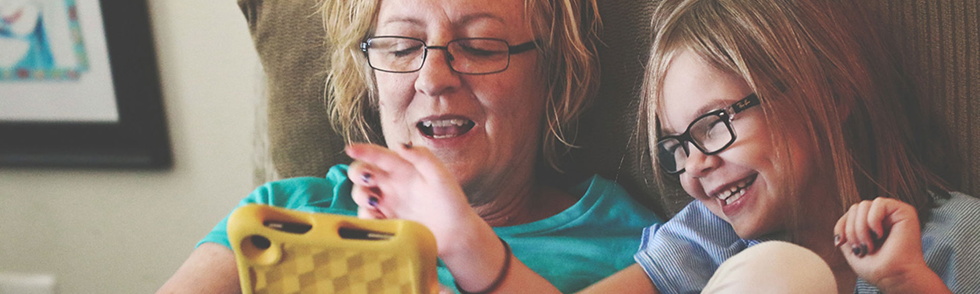 A woman and young girl using a tablet device together