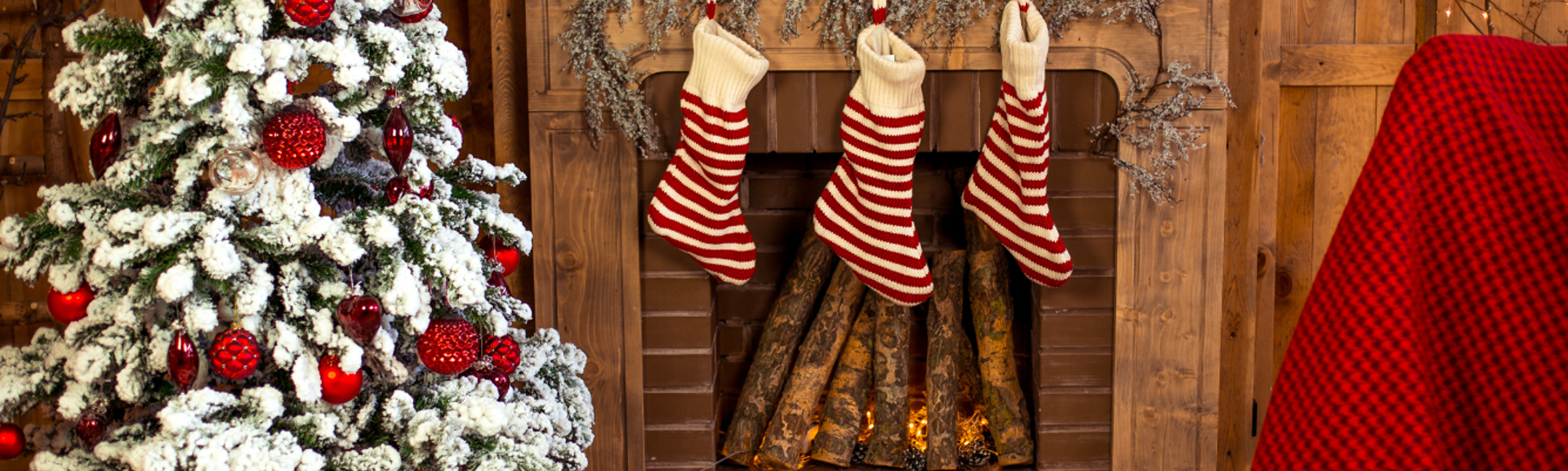 A Christmas scene with a tree, fireplace and stockings hanging from the mantlepiece