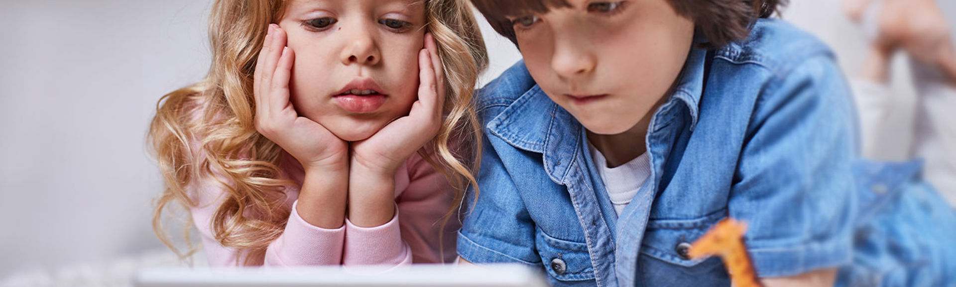 Two children looking at a tablet device together