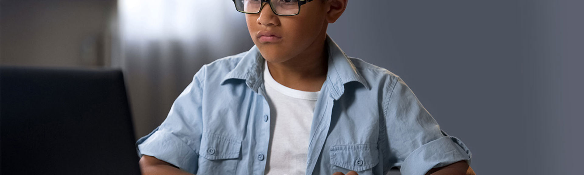 A boy looking at a computer screen with a confused look on his face