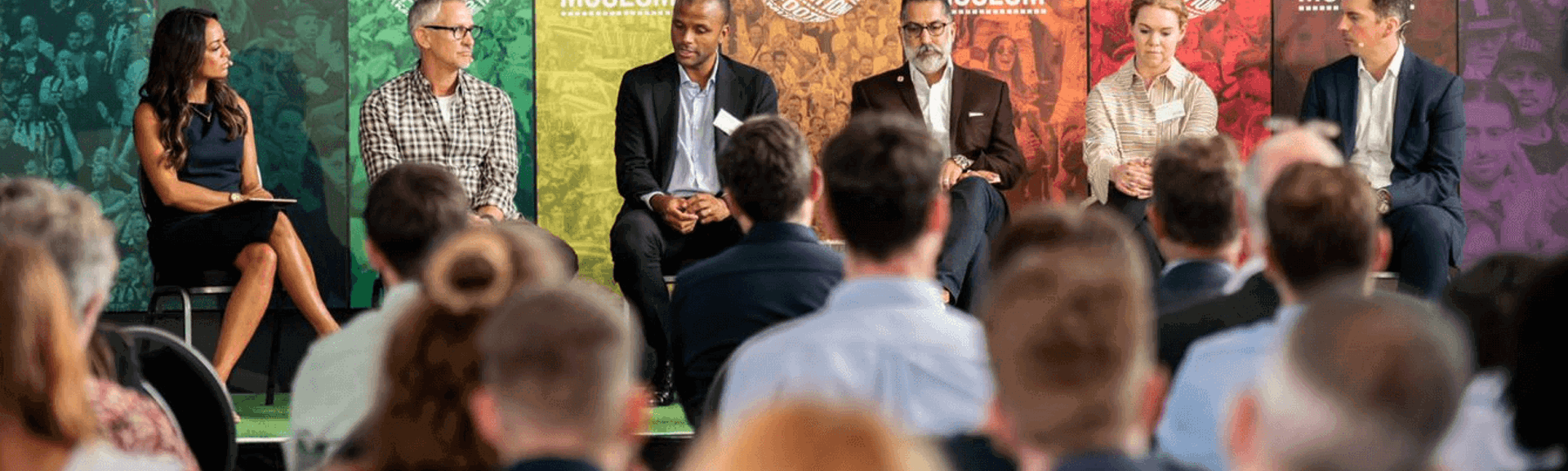A panel of people sitting on a stage