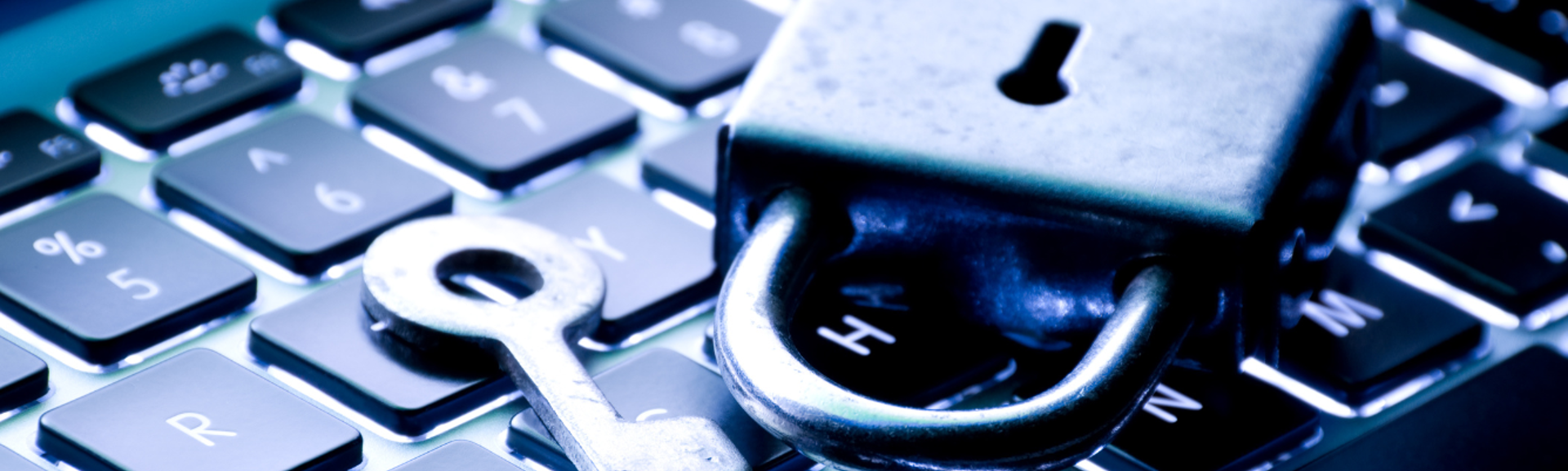 A padlock and key sitting on a laptop keyboard