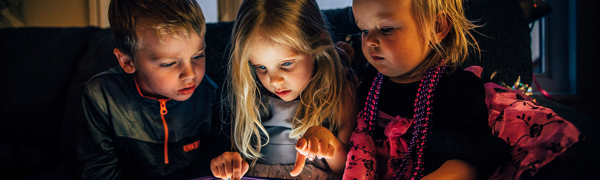 Three very young children looking at a tablet computer