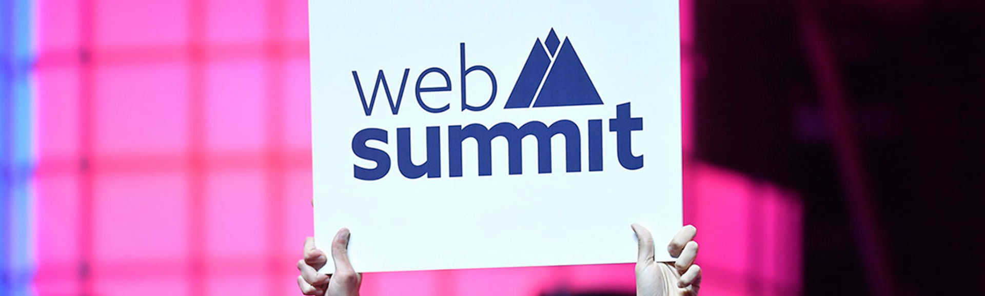 A person holding a sign with the words 'Web Summit' written on it