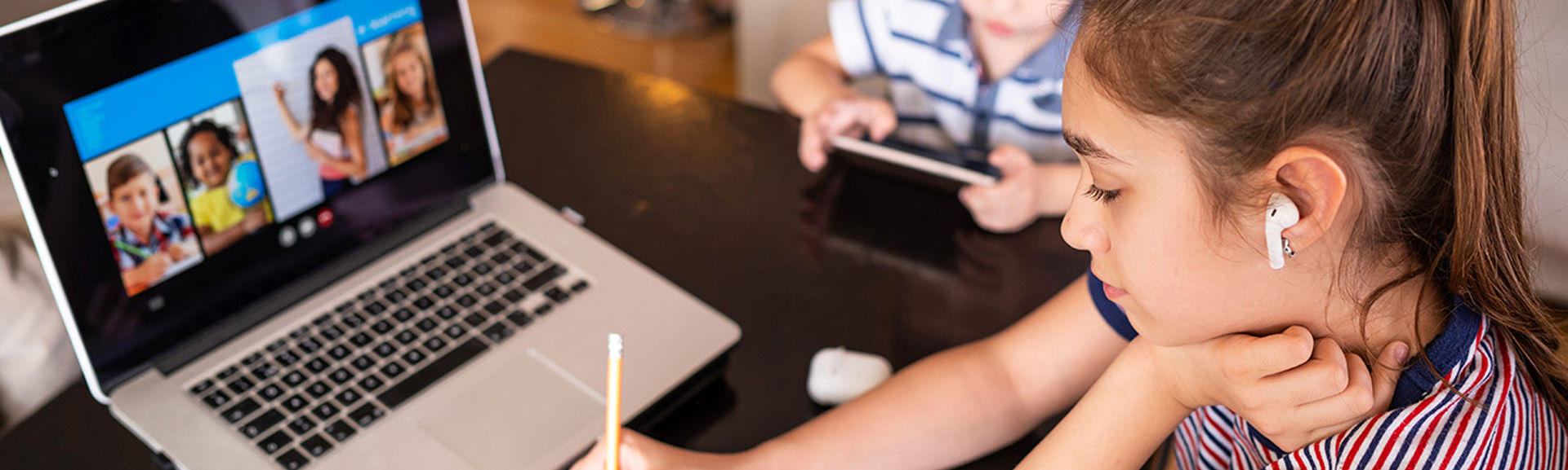 A young girl doing homework on a laptop computer