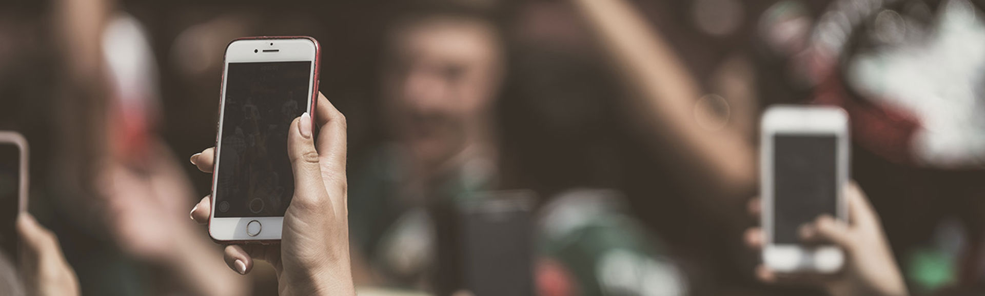 People holding smart phones in a crowded room