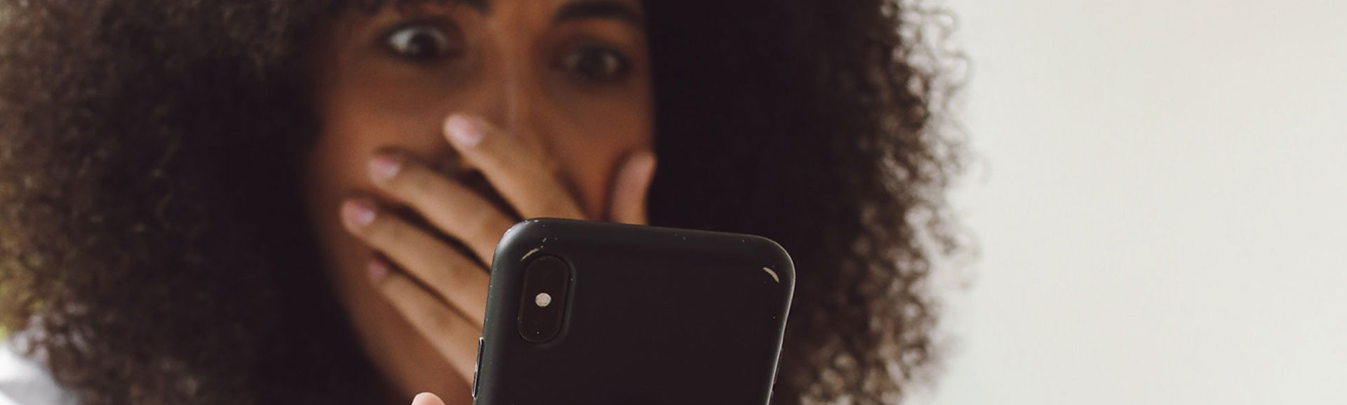 A shocked looking person looking at their phone screen
