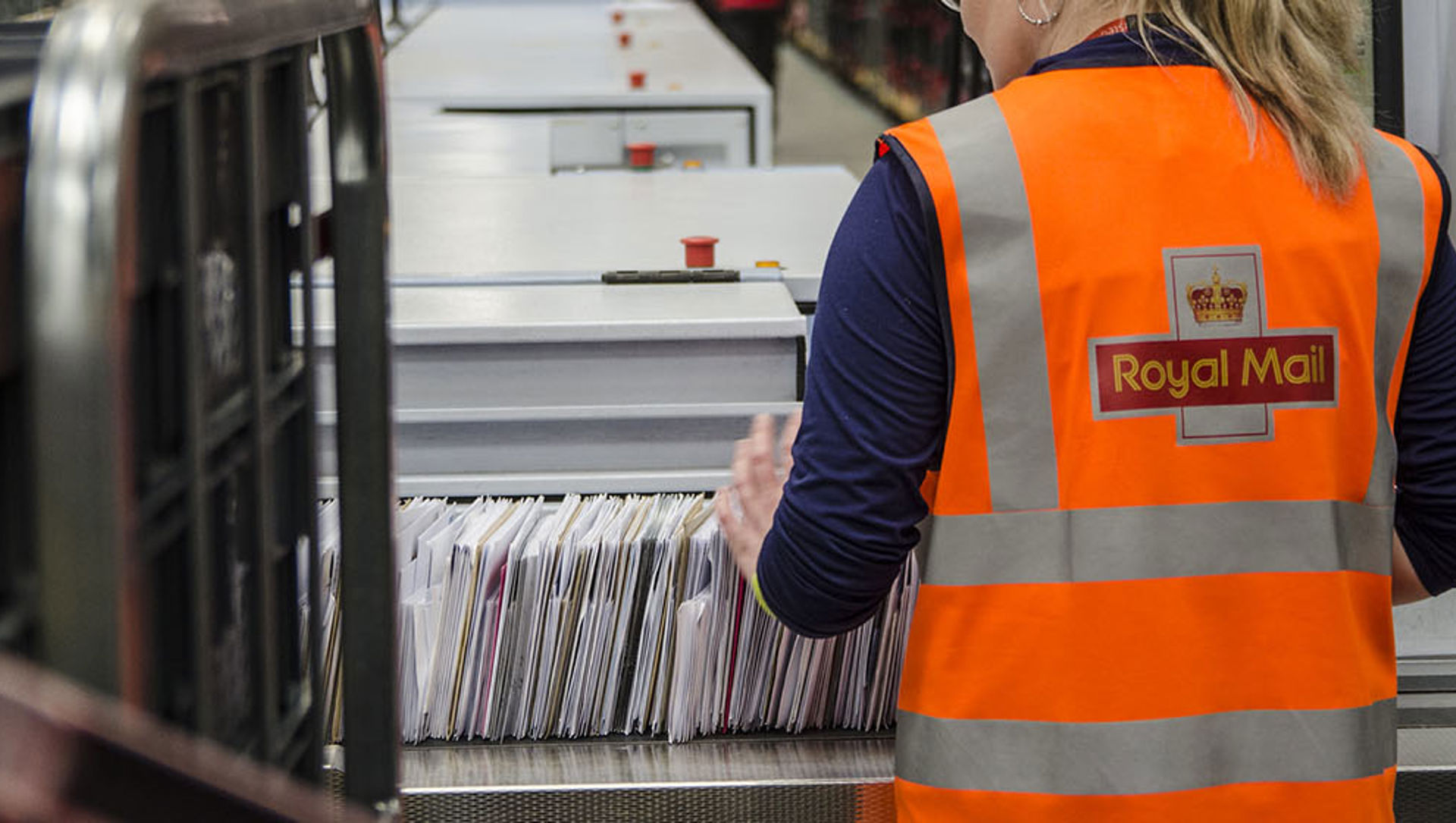 A Royal Mail employee sorting letters in a sorting office