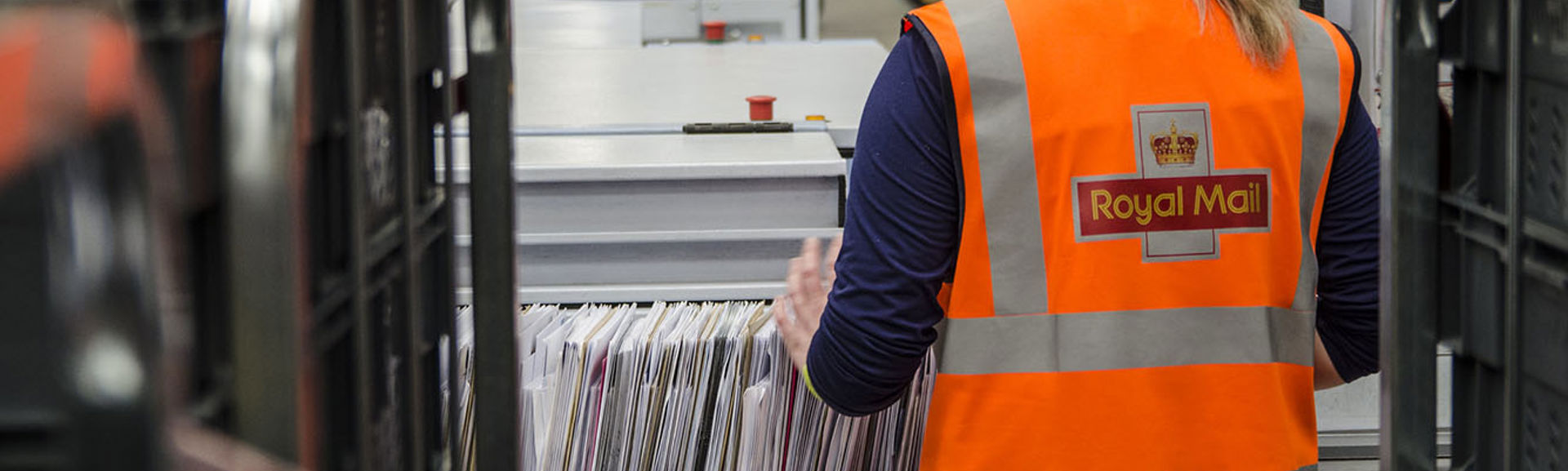 A Royal Mail employee sorting letters in a sorting office