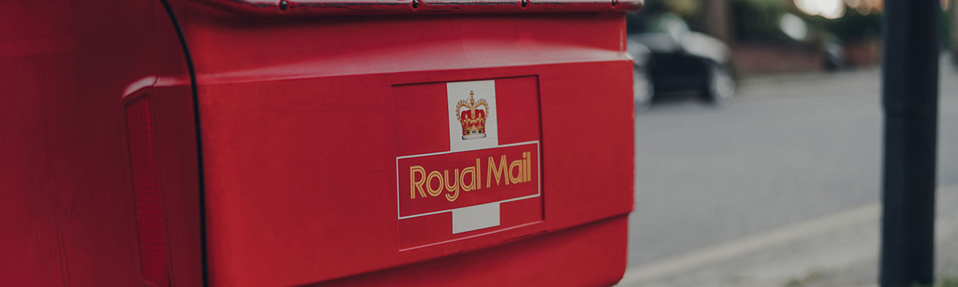 Red delivery troll belonging to Royal Mail on a street