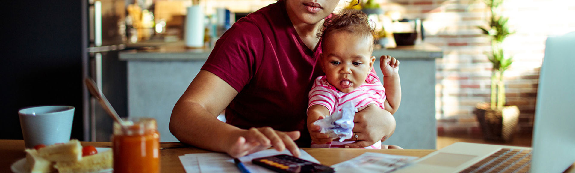 Woman with toddler using calculator on her phone