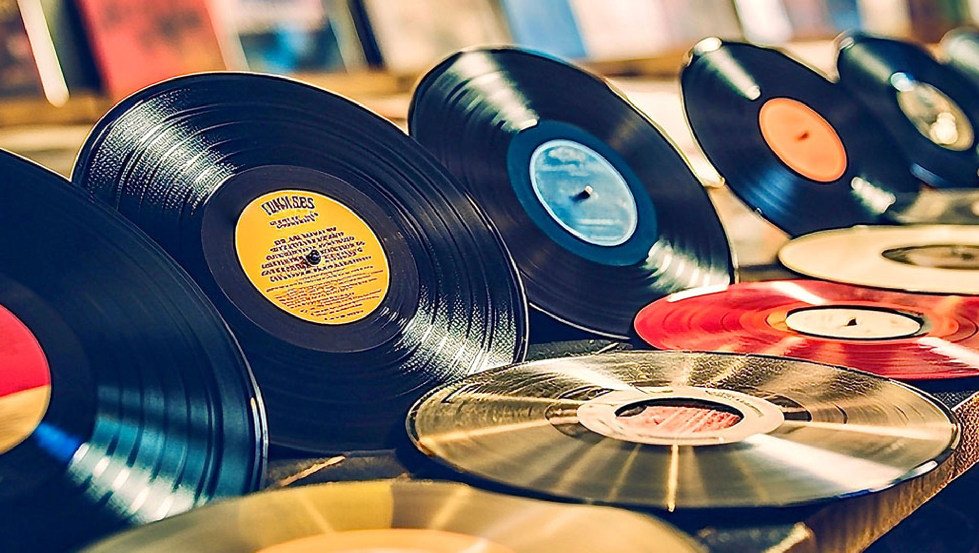 Vintage vinyl records and CDs on shelf in music shop. 