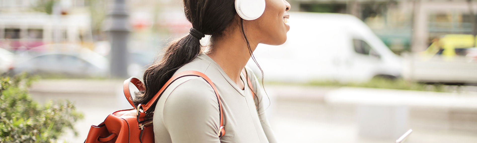 Young woman outdoors listening to a podcast on her smartphone