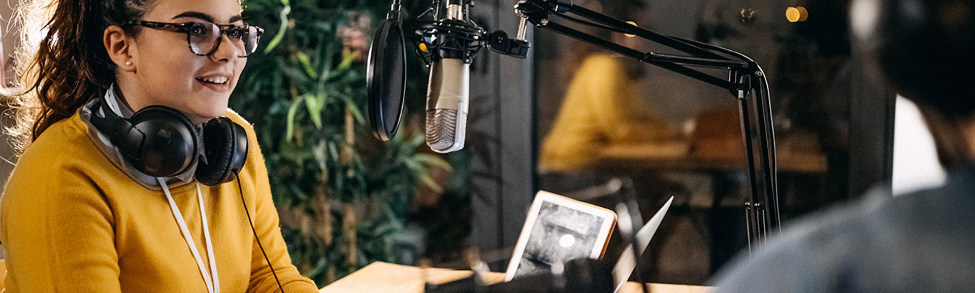 Young woman talking to somebody in a radio studio