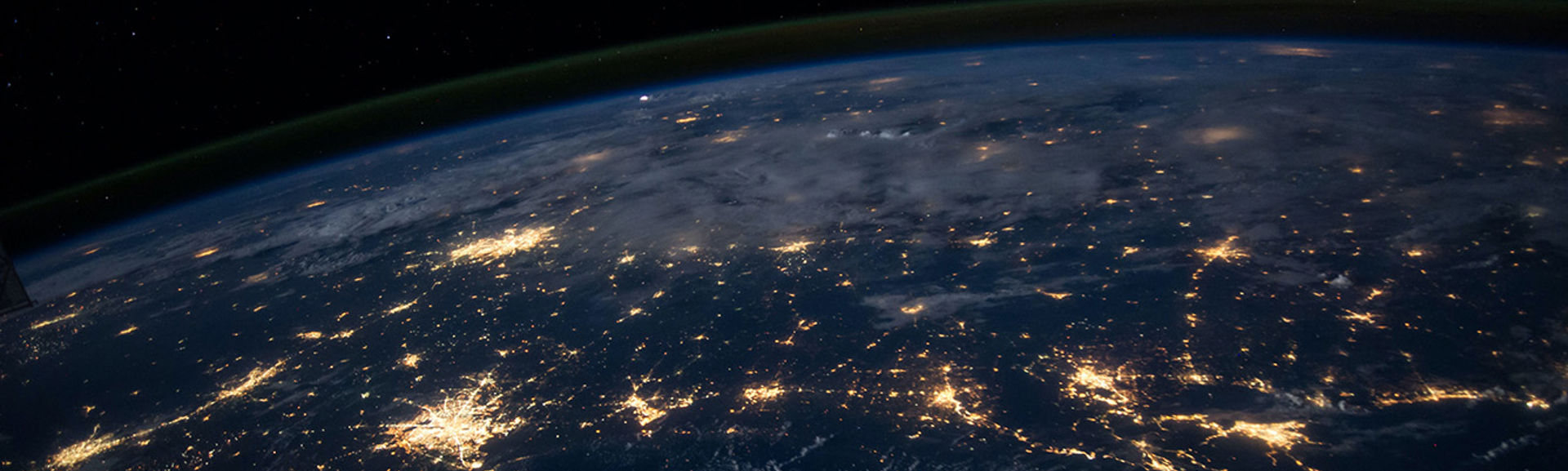 Satellite view of part of the earth at night time with cities glowing in light