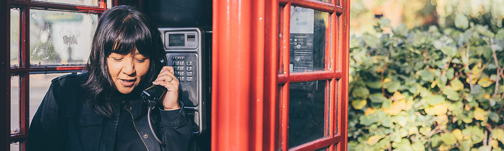 Selina Chadha, director of Consumer Policy inside of a phone box