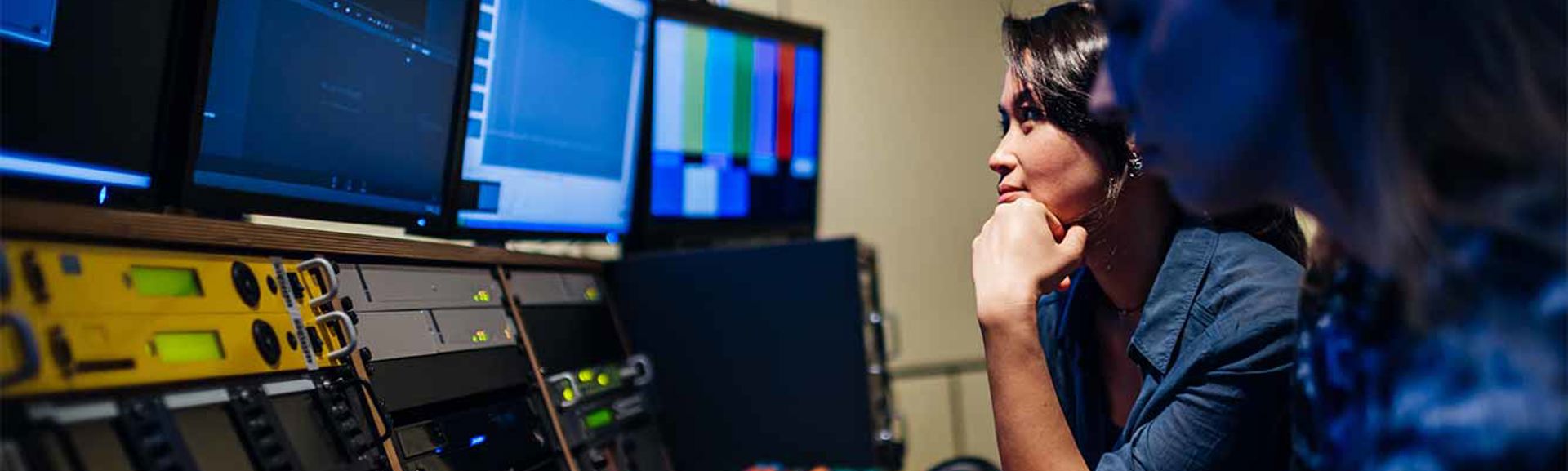 Two people working in the control room of a television studio