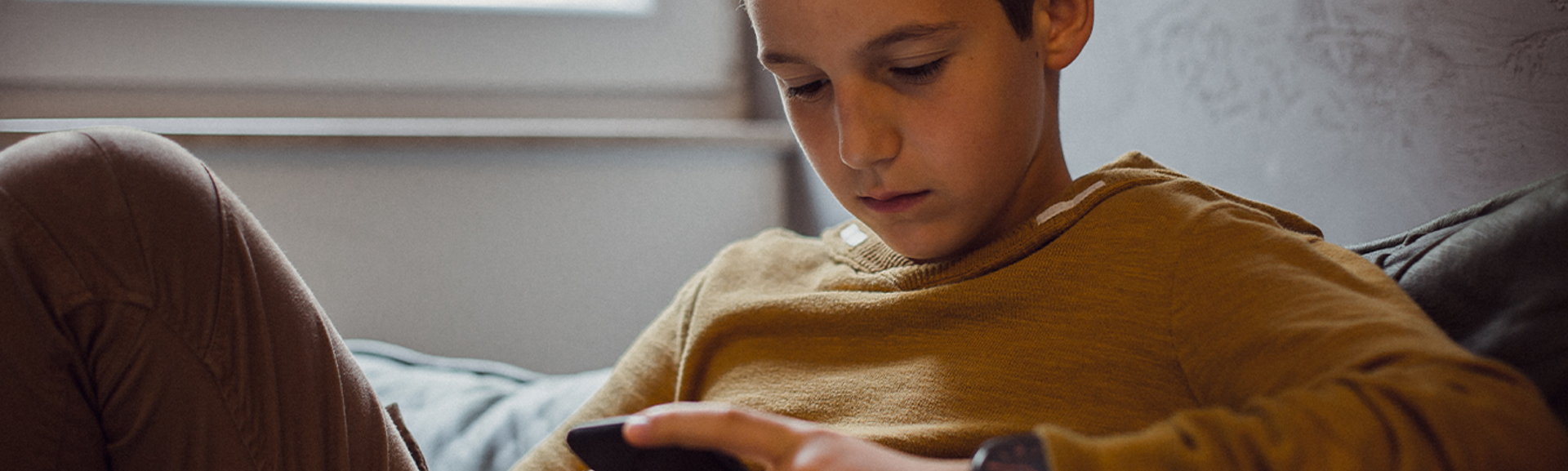 Young teenager looking at news on his phone