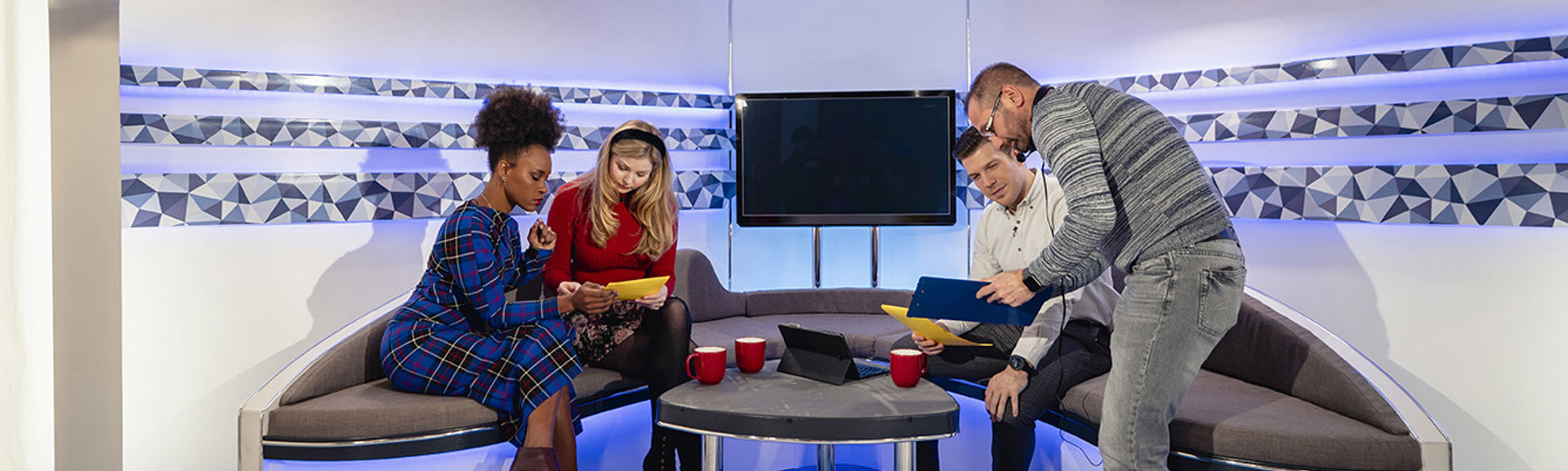 Producer speaking to presenters on a TV studio set