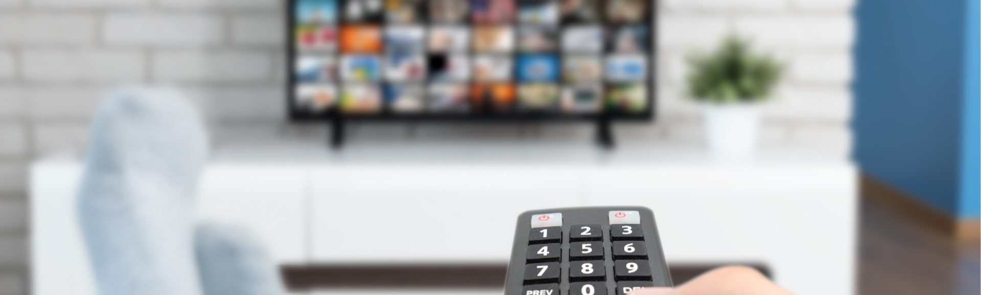 A person pointing a remote control at a television screen