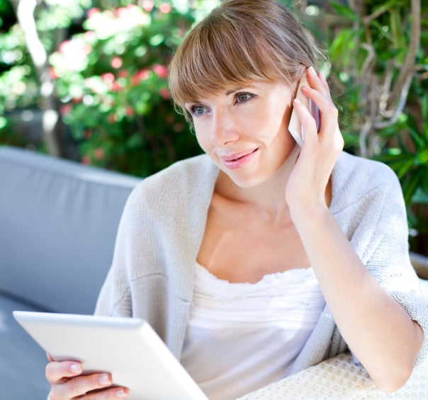 Woman on phone with tablet computer in hand
